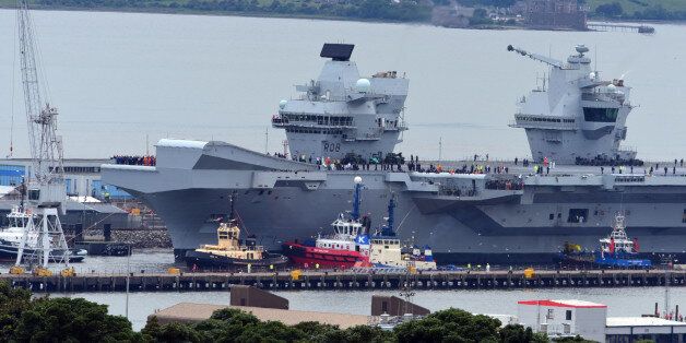 ROSYTH, SCOTLAND - JUNE 26: The aircraft carrier HMS Queen Elizabeth leaves Rosyth dockyard to begin sea trials before entering service with the fleet, on June 26, 2017 in Rosyth, Scotland. HMS Queen Elizabeth and her sister ship HMS Prince of Wales, which is still under construction at Rosyth, are the largest warships ever built for the Royal Navy (Photo by Ken Jack - Corbis/Corbis via Getty Images)