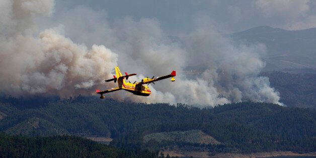 LEIRIA, PORTUGAL - JUNE 20: A firefighter plane works on a fire after a wildfire took dozens of lives on June 20, 2017 near Pedrogao Grande, in Leiria district, Portugal. On Saturday night, a forest fire became uncontrollable in the Leiria district, killing at least 64 people and leaving many injured. Some of the victims died inside their cars as they tried to flee the area. (Photo by Pablo Blazquez Dominguez/Getty Images)