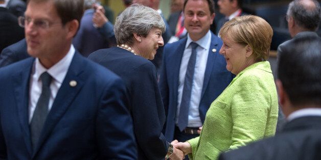 Theresa May, U.K. prime minister, center left, shakes hands with Angela Merkel, Germany's chancellor, center right, as Xavier Bettel, Luxembourg's prime minister, looks on ahead of round table talks during the European Union (EU) leaders summit at the Europa building in Brussels, Belgium, on Thursday, June 22, 2017. EU leaders are expected to reaffirm their commitment toÂ 'robust' free trade and the Paris Agreement on climate change when the two-day meeting concludes on Friday. Photographer: Jasper Juinen/Bloomberg via Getty Images