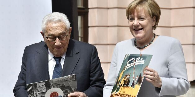 German Chancellor Angela Merkel and former US Secretary of State Henry Kissinger hold a recording of George Marshall on a vinyl record they received as a gift for participating in a conference titled '70 Years of Marshall Plan' organised by the German Marshall Funds of the United States at the Deutsches Historisches Museum in Berlin on June 21, 2017. / AFP PHOTO / John MACDOUGALL (Photo credit should read JOHN MACDOUGALL/AFP/Getty Images)