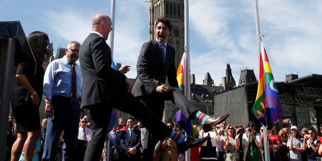 Canada's Prime Minister Justin Trudeau (R) compares socks with Liberal MP Randy Boissonnault during a pride flag raising ceremony on Parliament Hill in Ottawa, Ontario, Canada, June 14, 2017. REUTERS/Chris Wattie TPX IMAGES OF THE DAY
