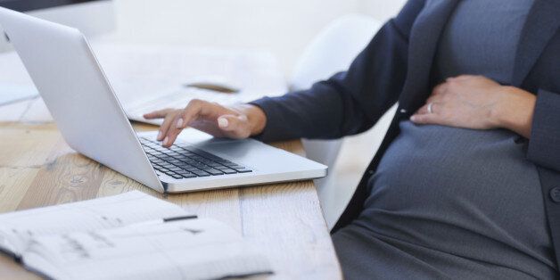 Cropped image of a pregnant businesswoman working on her laptop in the office