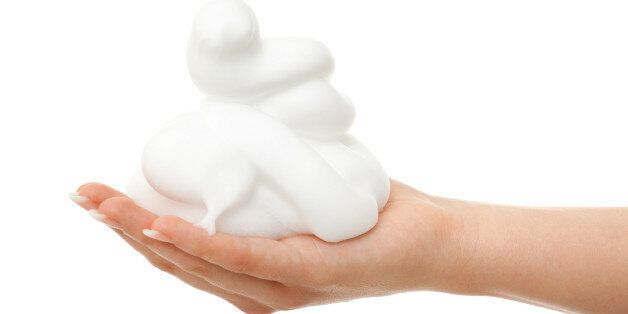 Side view of pretty female hand with a pile of foam. isolated against white background