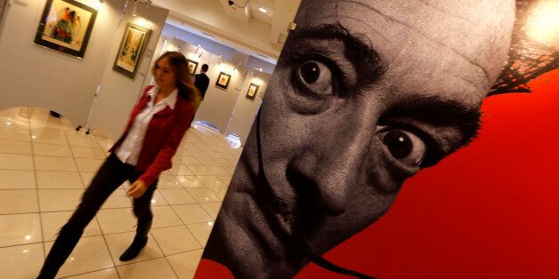 A visitor walks past a portrait of Salvador Dali during the exhibition