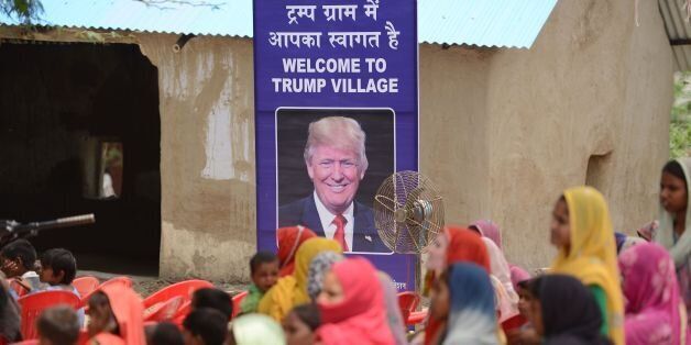 Indian women gather to listen to a speaker next to a poster with the image of US President Donald Trump during a ceremony at Marora village, which has been unofficially renamed 'Trump Village,' about 100km from New Delhi, on June 23, 2017.A rural Indian settlement with little electricity or running water renamed itself 'Trump Village' on June 23 in an unusual gesture to the American president ahead of Prime Minister Narendra Modi's trip to Washington. A huge billboard declaring 'Welcome to Trump Village' in Hindi and English, accompanied with a beaming portrait of the US president, was unveiled in Haryana state's Marora, as the village is officially known. The water and sanitation group Sulabh, which has been installing toilets in the impoverished settlement, suggested the name change to the local council. / AFP PHOTO / MONEY SHARMA (Photo credit should read MONEY SHARMA/AFP/Getty Images)