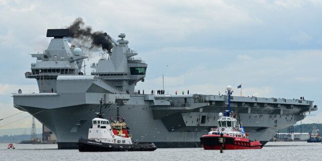 ROSYTH, SCOTLAND - JUNE 26: The aircraft carrier HMS Queen Elizabeth makes smoke as she leaves Rosyth dockyard to begin sea trials before entering service with the fleet, on June 26, 2017 in Rosyth, Scotland. HMS Queen Elizabeth and her sister ship HMS Prince of Wales, which is still under construction at Rosyth, are the largest warships ever built for the Royal Navy (Photo by Ken Jack - Corbis/Corbis via Getty Images)