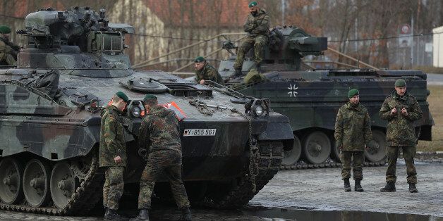 GRAFENWOEHR, GERMANY - FEBRUARY 21: Soldiers of the Bundeswehr, the German armed forces, prepare to drive Marder light tanks onto a train for transport to Lithuania on February 21, 2017 in Grafenwoehr, Germany. The Bundeswehr is participating in the enhanced Forward Presence operation of NATO, in which multinational contingents are strengthening the defensive capabilities of the three Baltic states and Poland in light of Russia's recent interventions in Crimea and eastern Ukraine. Germany is le
