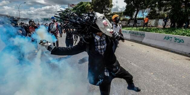 Opposition activists clash with riot police during a demonstration against the government of President Nicolas Maduro along the Francisco Fajardo highway in Caracas on June 19, 2017.Near-daily protests against President Nicolas Maduro began on April 1, with demonstrators demanding his removal and the holding of new elections. The demonstrations have often turned violent with 73 people killed and more than 1,000 injured so far, prosecutors say, and more than 3,000 arrested, according to the NGO Forum Penal. / AFP PHOTO / Juan BARRETO (Photo credit should read JUAN BARRETO/AFP/Getty Images)