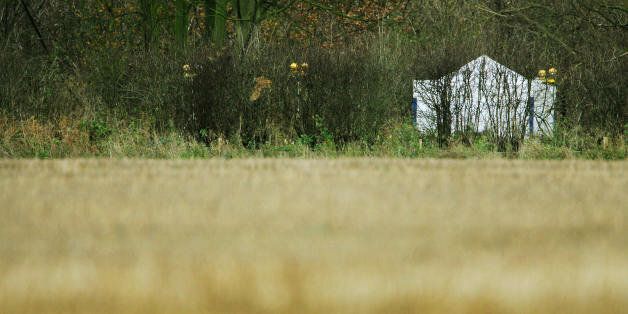 Ipswich, UNITED KINGDOM: A police forensic tent is pictured in a field close to the village of Levington, near Ipswich in Suffolk, 14 December 2006, almost 48 hours after the bodies of two more prostitutes were discovered in woodland. England's serial killer manhunt has opened a pandora's box of criticism by sex workers, who claim police ignore attacks on them, and harrass them because their activities are illegal. A hardcore of prostitutes remains on the streets of Ipswich this week despite th