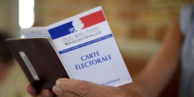 A woman holds a electoral card at a polling station in Carhaix-Plouguer, western France, during the second round of the French parliamentary elections (elections legislatives in French) on June 18, 2017. / AFP PHOTO / Fred TANNEAU (Photo credit should read FRED TANNEAU/AFP/Getty Images)