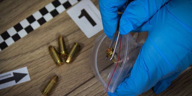 Forensic experts collects evidence from the crime scene. Bullets packed in a bag with a pair of tweezers
