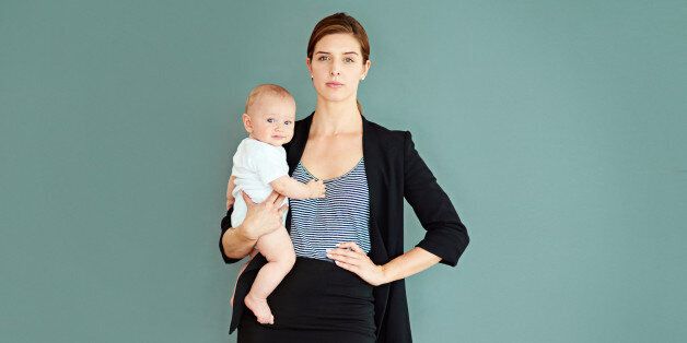 Studio shot of a successful young businesswoman carrying her adorable baby boy