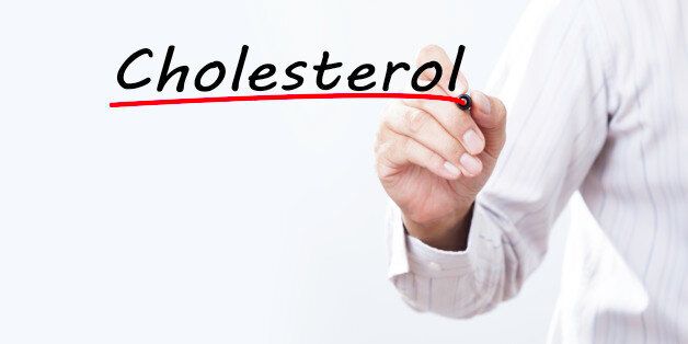 Businessman hand writing 'Cholesterol' with red marker on transparent wipe board