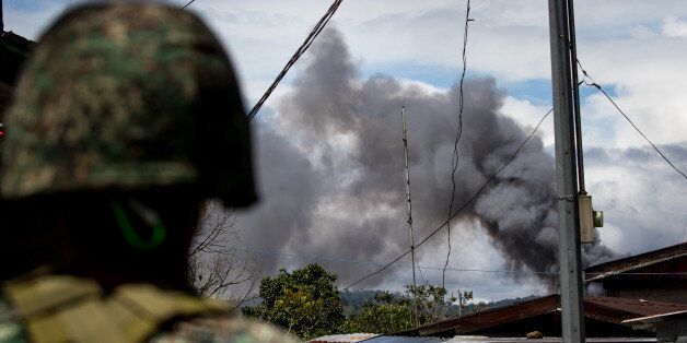 Philippine marines look at smoke following an airstrikes by Philippine Air Force in Marawi, southern Philippines on June 9, 2017. Philippine military jets fired rockets at militant positions on Friday as soldiers fought to wrest control of the southern city from gunmen linked to the Islamic State group.(Photo by Richard Atrero de Guzman/NurPhoto via Getty Images)