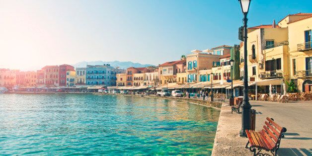 view of waterfront promenade with bars, hotels and restaurants in central historic part of Chania on sunny summer day, Crete, Greece
