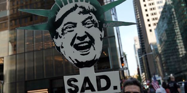 A protester displays a placard during a demonstration against US President Donald Trump to mark his birthday, in New York on June 14, 2017. / AFP PHOTO / Jewel SAMAD (Photo credit should read JEWEL SAMAD/AFP/Getty Images)