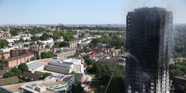 A firefighter directs a jet of water at a tower block severely damaged by a serious fire, in north Kensington, West London, Britain June 14, 2017. REUTERS/Neil Hall