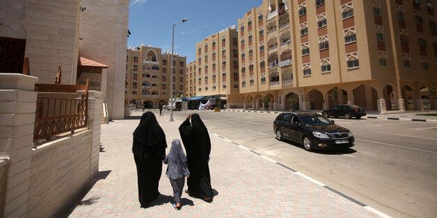 Palestinians walk on a site before the construction of housing units funded by Qatar in Khan Yunis in the southern Gaza Strip on the seventh of June 2017. (Photo by Majdi Fathi/NurPhoto via Getty Images)