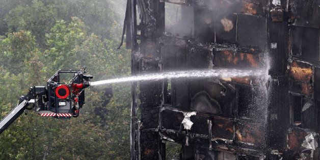 LONDON, ENGLAND - JUNE 15: A hose continues to douse the fire at Grenfell Tower on June 15, 2017 in London, England. At least 17 people have been confirmed dead and dozens missing, after the 24 storey residential Grenfell Tower block in Latimer Road was engulfed in flames in the early hours of June 14. The number of fatalities are expected to rise. (Photo by Dan Kitwood/Getty Images)