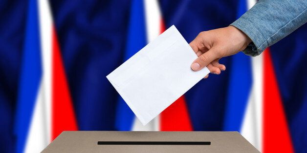 Election in France. The hand of woman putting her vote in the ballot box. French flags on background.