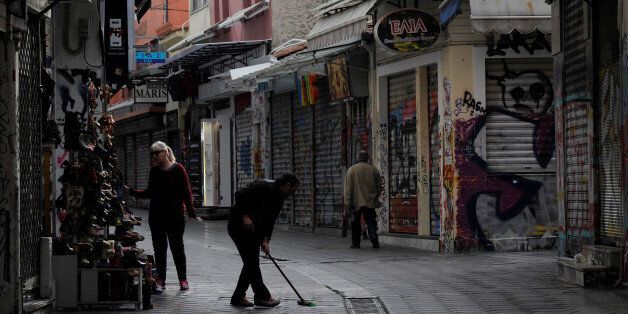 A man sweeps a pedestrian street in front of his shop at Monastiraki area in early morning before shops open in central Athens, Greece, February 27, 2017. REUTERS/Michalis Karagiannis