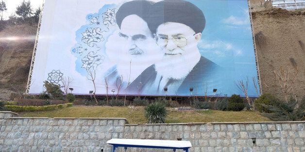 FILE PHOTO: Iranian youths sit under a large picture of Iran's late leader Ayatollah Ruhollah Khomeini (L), and Iran's Supreme Leader Ayatollah Ali Khamenei at a park in Tehran, Iran, January 17, 2016. REUTERS/Raheb Homavandi/TIMA/File Photo ATTENTION EDITORS - THIS IMAGE WAS PROVIDED BY A THIRD PARTY. FOR EDITORIAL USE ONLY