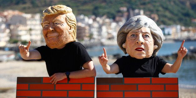 Protesters wear masks depicting U.S. President Donald Trump and Britain's Prime Minister Theresa May during a demonstration against a G7 summit organised by Oxfam in Giardini Naxos near Taormina, Sicily, Italy, May 27, 2017. REUTERS/Yara Nardi