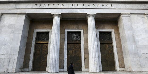 A pedestrian passes the entrance to the headquarters of the Bank of Greece in Athens, Greece, on Tuesday, Feb. 28, 2017. Greeces auditors are pulling together a list of policies the country needs to implement to unlock additional bailout funds as talks with Athens resumed on Tuesday, two people familiar with the matter said. Photographer: Yorgos Karahalis/Bloomberg via Getty Images
