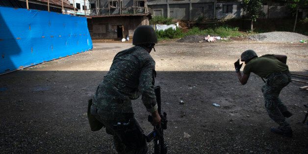 MARAWI CITY, PHILIPPINES - MAY 30: Filipino soldiers engage in a firefight with ISIS-linked militants, on May 30, 2017 in Marawi city, southern Philippines. Philippine government troops are battling their way as they inch towards the city center where ISIS-linked militants have been holed for nearly a week. The fighting at Marawi city had forced around 85,000 people to seek refuge at evacuation centers in Marawi as the week long gun battles between ISIS-linked militants and security troops rose to around 100 with at least 19 civilians being killed in the fighting, according to local media. Filipino authorities announced around 2,000 people had been stranded amid street battles and air strikes while bodies of foreign Islamist militants were discovered during the ongoing battles in the southern city. President Rodrigo Duterte had declared 60 days of martial law in Mindanao on Tuesday after local terrorist groups Maute Group and Abu Sayyaf rampaged through Marawi city and said that martial law could be extended across the Philippines while thousands of residents continue to flee the crisis in Marawi, which is home to some 200,000 people. Jes Aznar/Getty Images
