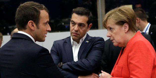 (L-R) French President Emmanuel Macron, Greek Prime Minister Alexis Tsipras and German Chancellor Angela Merkel speak during a working dinner meeting at the NATO (North Atlantic Treaty Organization) summit at the NATO headquarters, in Brussels, on May 25, 2017. / AFP PHOTO / POOL / Matt Dunham (Photo credit should read MATT DUNHAM/AFP/Getty Images)