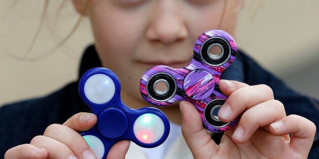 PARIS, FRANCE - MAY 20: In this photo illustration, a child shows a 'Hand Spinner' on May 20, 2017 in Paris, France. The 'Hand Spinner' is a toy that sits like a propeller on a person's finger, with blades that spin around a bearing. Since a month the 'Hand spinner' or 'Fidget spinner', a whirligig from the United States has become a mondial phenomenon to the point of creating stock shortages in toy stores. (Photo Illustration by Chesnot/Getty Images)