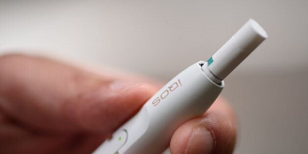 A Philip Morris International Inc. iQOS electronic cigarette is held for a photograph in Tokyo, Japan, on Tuesday, Aug.23, 2016. Philip Morris International and Japan Tobacco Inc. have rolled out products that are heated -- not burned -- in battery-charged devices, seeking to appeal to smokers who want their nicotine fix without the usual smell and smoke. Photographer: Akio Kon/Bloomberg via Getty Images