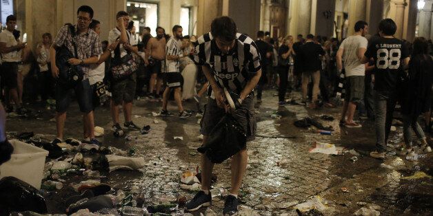Juventus' supporters look for personal belongings in Piazza San Carlo after a panic movement in the fanzone where thousands of Juventus fans were watching the UEFA Champions League Final football match between Juventus and Real Madrid on a giant screen, on June 3, 2017in Turin. / AFP PHOTO / Marco BERTORELLO (Photo credit should read MARCO BERTORELLO/AFP/Getty Images)