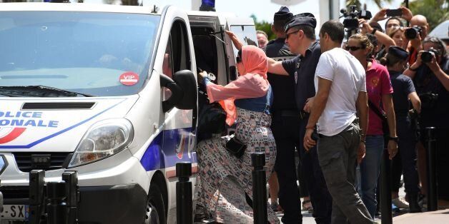 A woman enters a Police van after being arrested by Police on May 26, 2017 outside the luxury Martinez hotel, before she attempted with other women to take part in a bathing in full-body Islamic burkini swimsuit on a beach of Cannes, during the 70th edition of the Cannes Film Festival in Cannes, southern France. About ten women who planned to bath in burkini on May 26 were arrested by police in Cannes, in front of the luxury Martinez hotel, on the grounds no demonstration had been allowed by the prefecture. The women, who all came by train from Paris for the event, are friends or relatives of Algerian businessman Rachid Nekkaz, who has made himself known since 2010 by paying the fines of women who dot not comply with France's local legislation. Nekkaz said by attempting to organise the event, he was aiming at recalling an August 26, 2016 court ruling by the Council of State that suspended the burkini ban. / AFP PHOTO / Anne-Christine POUJOULAT (Photo credit should read ANNE-CHRISTINE POUJOULAT/AFP/Getty Images)