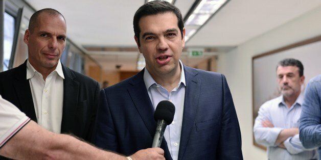 Greek prime minister Alexis Tsipras (C) talks to media at the finance ministry in Athens , after his meeting with the finance minister Yianis Varoufakis (L) and other government officials on May 27, 2015. Technical experts representing Greece and its creditors are to start drafting on May 27, 2015 a long-awaited agreement that would release much needed bailout loans for the struggling eurozone country, a Greek government source said. AFP PHOTO / LOUISA GOULIAMAKI (Photo credit should read