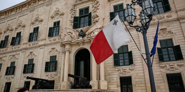 Canons and a Maltese flag sit on display outside the Auberge de Castille in Valletta, Malta, on Wednesday, Oct. 21, 2015. ECB President Mario Draghi will convene his Governing Council on the Mediterranean island of Malta this week to set monetary policy for a 19-nation region that is seeing its recovery buffeted by slowing international trade and global market volatility. Photographer: Yorgos Karahalis/Bloomberg via Getty Images