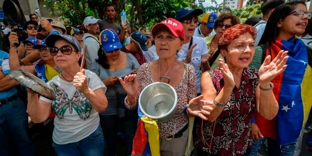 Opposition activists take part in a protest against President Nicolas Maduro's government, in Caracas on June 3, 2017.Venezuela's President Nicolas Maduro has offered to hold a referendum on contested constitutional reforms in an apparent bid to calm critics in his own camp as he resists opposition efforts to remove him from office. The surprise announcement late Thursday followed two months of deadly unrest during anti-government protests and signs of division in the socialist leader's side. / AFP PHOTO / LUIS ROBAYO (Photo credit should read LUIS ROBAYO/AFP/Getty Images)