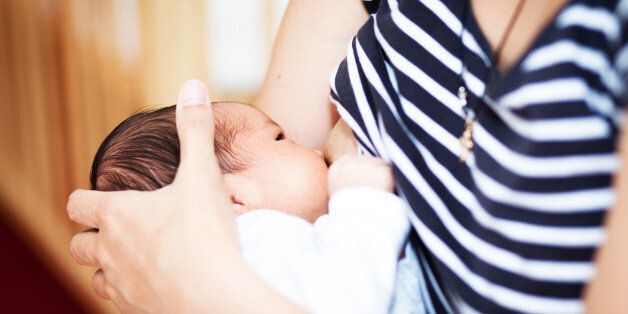 Mother breastfeeding a newborn baby girl.