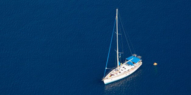 Looking down to the sea with a single sailboat, Santorini.