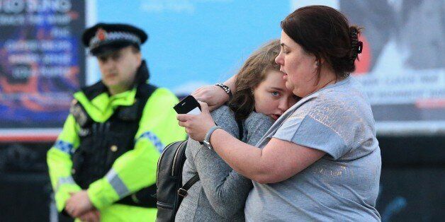 MANCHESTER, UNITED KINGDOM - MAY 23: Walking casualties Vikki Baker and her thirteen year old daughter Charlotte hug outside the Manchester Arena stadium in Manchester, United Kingdom on May 23, 2017. A large explosion was reported at the end of a concert by American singer Ariana Grande. So far, police have confirmed 20 dead and over fifty injured in the explosion, now thought to be terrorist-related. (Photo by Lindsey Parnaby/Anadolu Agency/Getty Images)