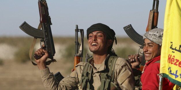 Fighters from the Democratic Forces of Syria carry their weapons as they cheer near the Syrian town of al Houl in Hasaka province, after they took control of the area, November 14, 2015. A U.S.-backed Syrian rebel alliance on Friday captured the town of al Houl in Hasaka province, which had been held by Islamic State militants, a spokesman for the Kurdish fighters, part of the grouping, said. It was the first significant advance against IS by the Democratic Forces of Syria, which was formed last month. REUTERS/Rodi Said