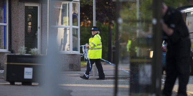 A policewoman gathers police tape during a security operation at Springfield Street in Wigan, Greater Manchester on May 25, 2017. / AFP PHOTO / Jon Super / JON SUPER (Photo credit should read JON SUPER/AFP/Getty Images)