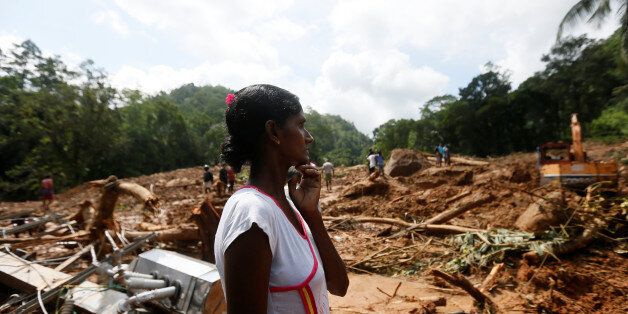 A woman reacts next to the debris of houses at a landslide site during a rescue mission in Athwelthota village, in Kalutara, Sri Lanka May 28, 2017. REUTERS/Dinuka Liyanawatte