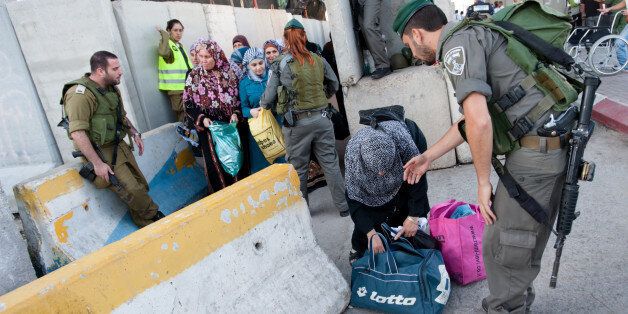 Bethlehem, Occupied Palestinian Territories - August 17, 2012: Israeli soldiers check Palestinian women and children at the Bethlehem checkpoint on the last Friday of Ramadan.