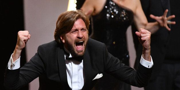 Swedish director Ruben Ostlund reacts on stage after he was awarded with the Palme d'Or for the film 'The Square' on May 28, 2017 during the closing ceremony of the 70th edition of the Cannes Film Festival in Cannes, southern France. / AFP PHOTO / Alberto PIZZOLI (Photo credit should read ALBERTO PIZZOLI/AFP/Getty Images)