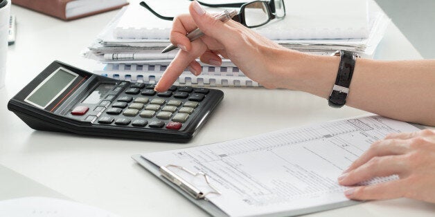 Close up of female accountant or banker making calculations. Savings, finances and economy concept