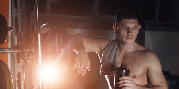 Handsome man with big muscles, posing at the camera in the gym