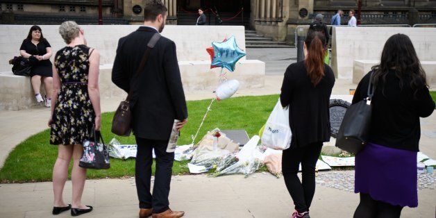MANCHESTER, ENGLAND - MAY 24: Members of the public pause to look at floral tributes and messages as the working day begins on May 24, 2017 in Manchester, England. An explosion occurred at Manchester Arena on the evening of May 22 as concert goers were leaving the venue after Ariana Grande had performed. Greater Manchester Police are treating the explosion as a terrorist attack and have confirmed 22 fatalities and 59 injured. (Photo by Leon Neal/Getty Images)