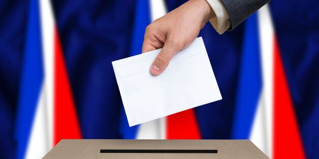 Election in France. The hand of man putting his vote in the ballot box. French flags on background.
