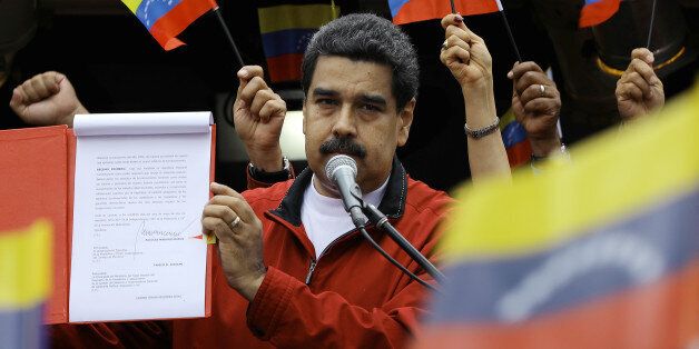Venezuela's President Nicolas Maduro shows a document with the details of a
